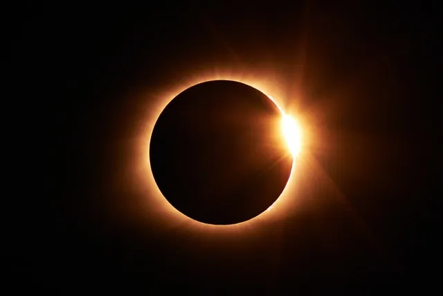 Le soleil brille à travers la couronne d'une éclipse totale, créant un spectacle lumineux et mystérieux.